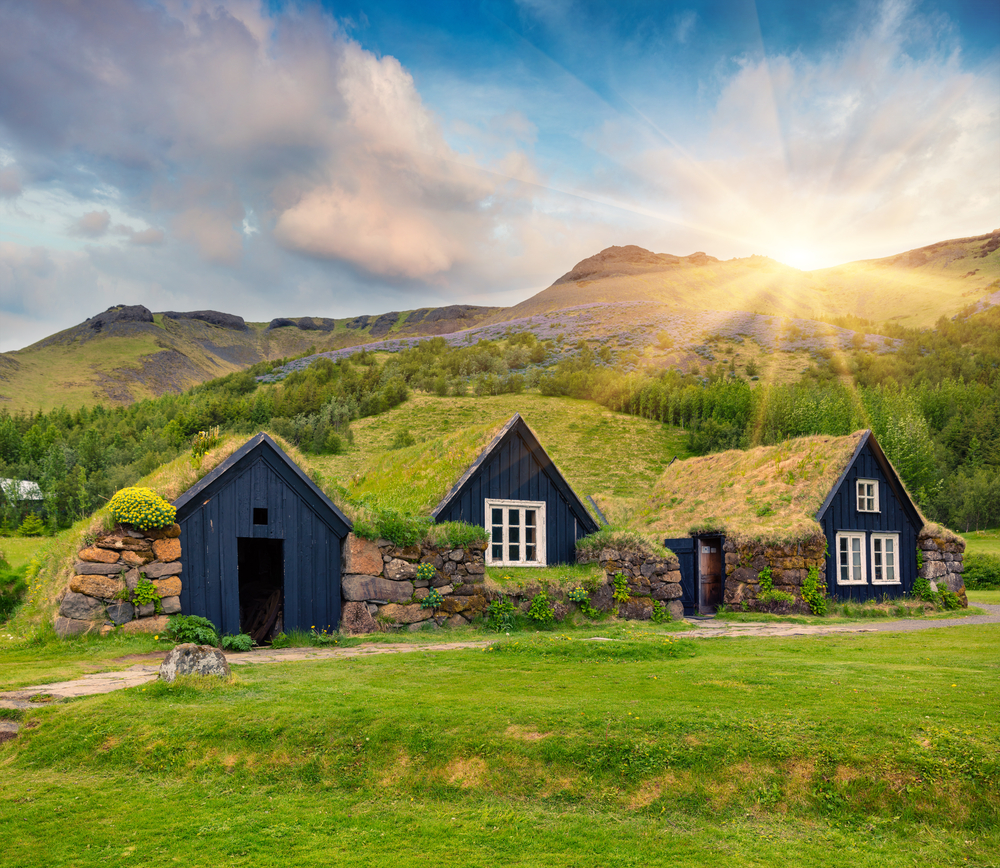 Typische Grasdach-Häuser in Island in grüner Umgebung. 